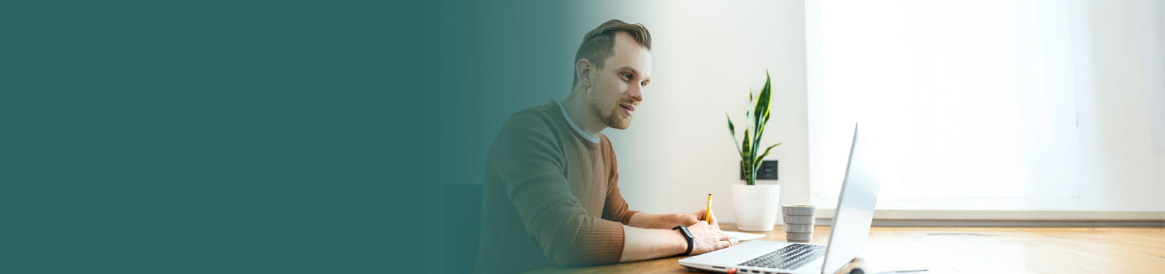 casually dressed businessman working at a computer at a table